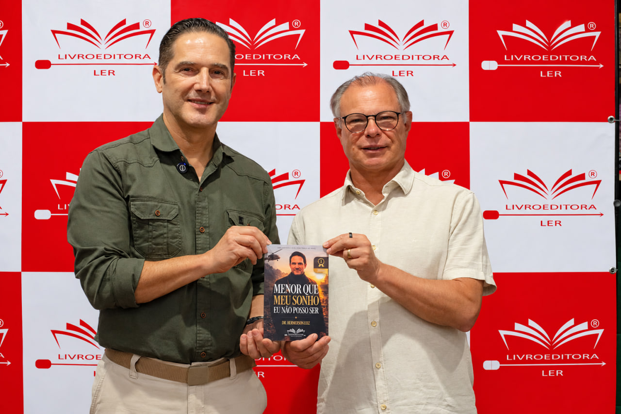 Dr. Hemerson Luz com um convidado segurando o livro no lançamento