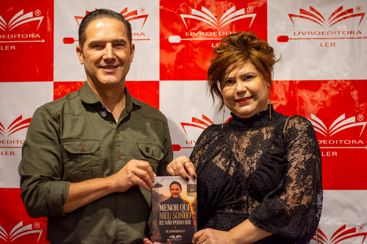 Dr. Hemerson Luz com uma convidada segurando o livro no lançamento