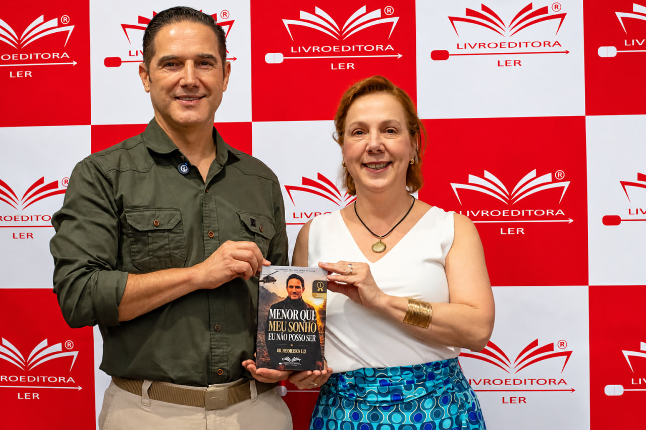 Dr. Hemerson Luz com uma leitora segurando o livro