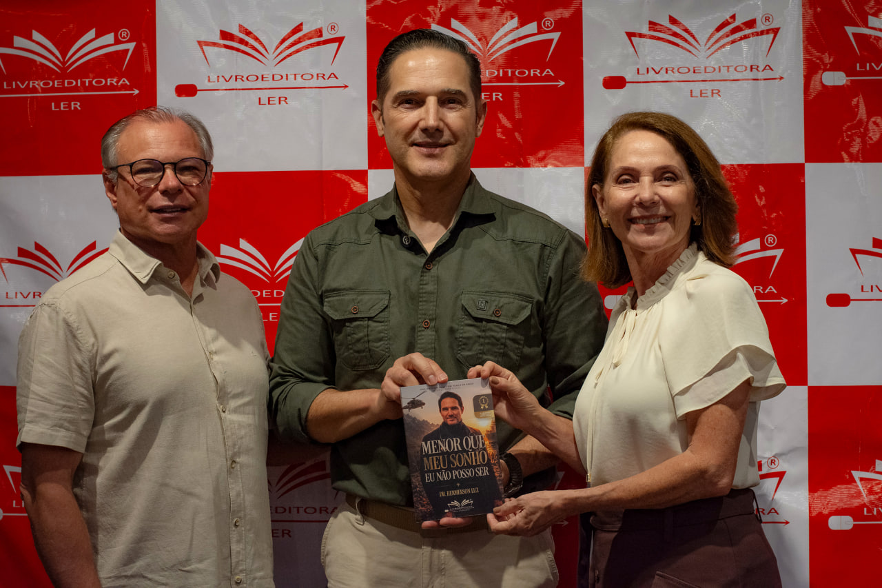 Dr. Hemerson Luz com leitores segurando o livro no lançamento